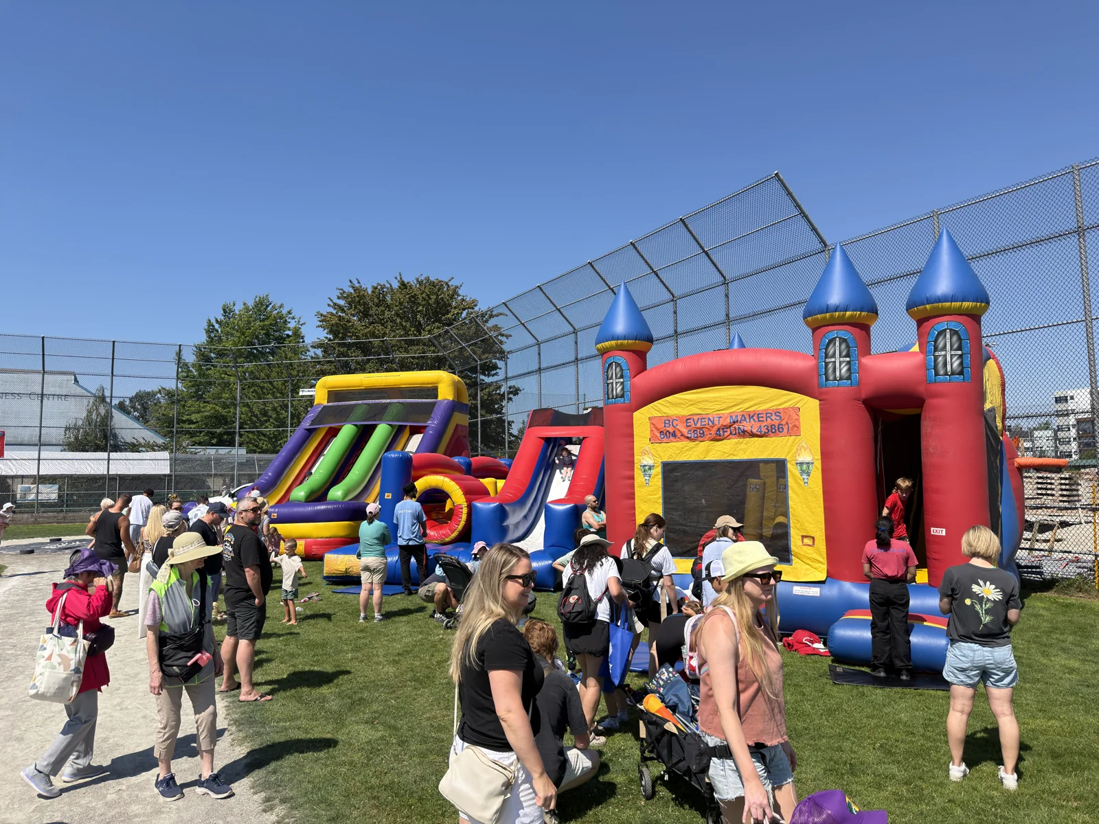 Families gathering around BC Event Makers inflatables at an outdoor event