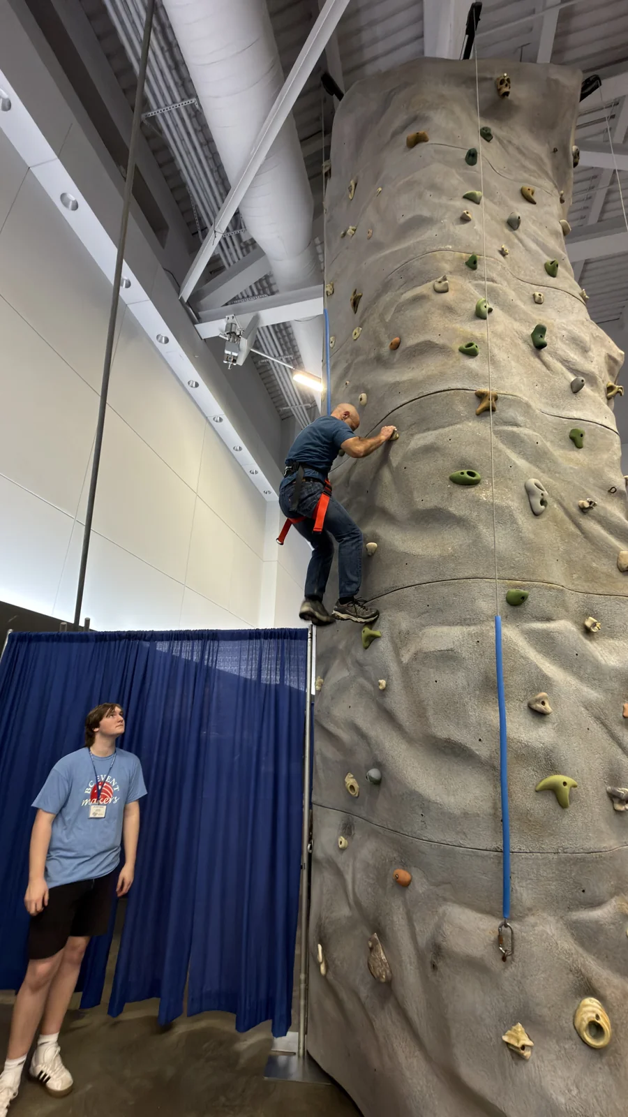 A guest climbing the BC Event Makers portable rock wall at an indoor event